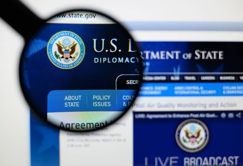 Photo of us department of state page on a monitor screen | US State Department Issues Advisory, Cuts Embassy Staff