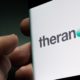 Theranos company logo seen on smartphone screen | Theranos Founder Elizabeth Holmes Found Guilty on 4 Counts of Fraud | featured