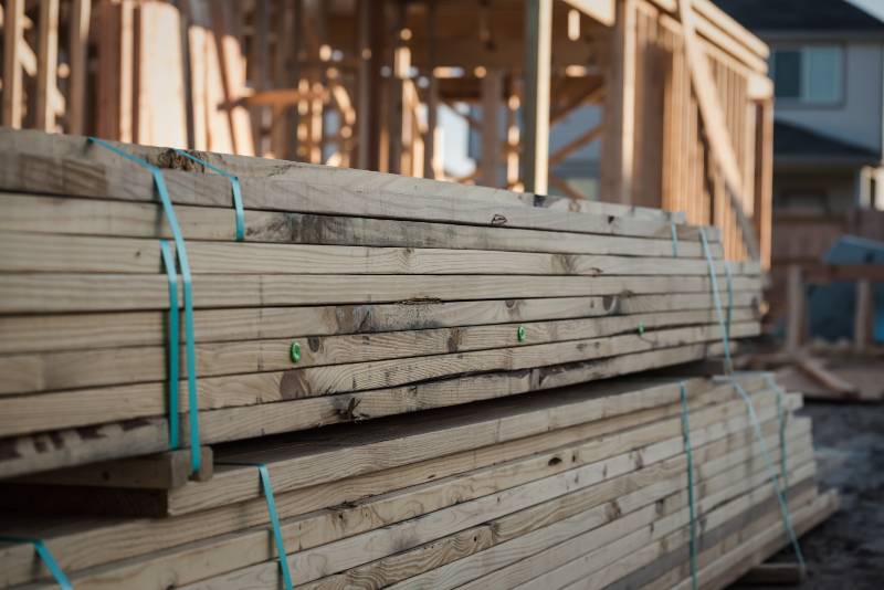A pile of lumber at a new home construction site | Housing Market Having With High Lumber Prices