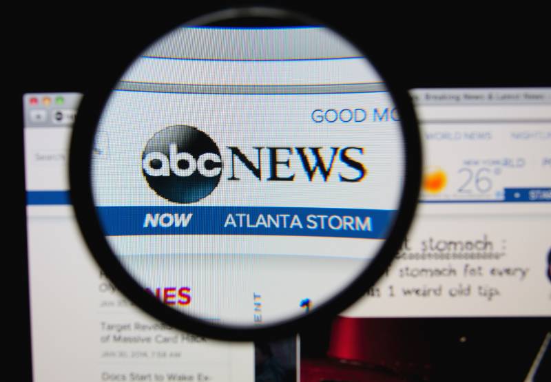ABC News homepage on a monitor screen through a magnifying glass | ABC Suspends Whoopi Goldberg for Two Weeks