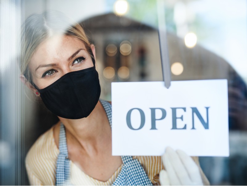 Coffee shop woman owner with face mask, open after lockdown quarantine | Denmark Ends COVID Restrictions Beginning February 1