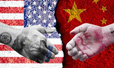 US dollar and China Yuan banknote print screen on handshake with both flags countries | China Didn’t Buy $200 Billion Worth of US Goods It Said It Will | featured
