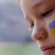 A child with the flag of Ukraine is crying | US To Accept 10,000 Ukrainian Refugees | featured