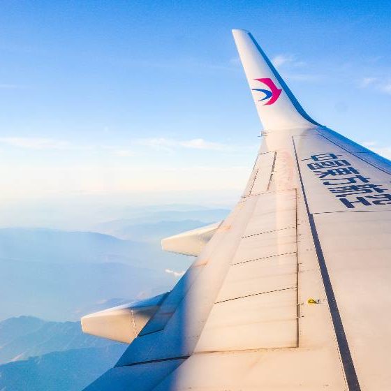 China Eastern Airplane's wing over beautiful blue sky and mountain ranges | Boeing 737-800 Crashes in China, 132 Presumed Dead | featured