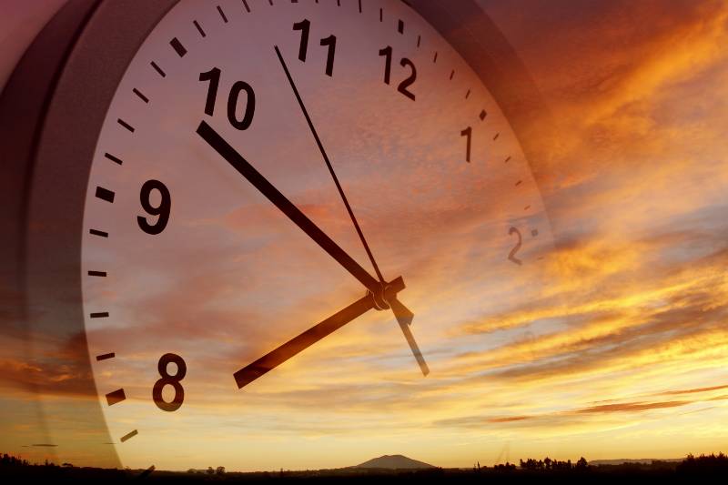 Clock face in bright sky | Sunshine Protection Act Makes Daylight Saving Time Permanent
