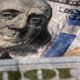 Closeup on Benjamin Franklin portrait on a one hundred US American paper banknote currency | US Recession Looms As Federal Reserve Hikes Interest Rates | featured