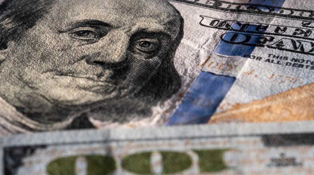 Closeup on Benjamin Franklin portrait on a one hundred US American paper banknote currency | US Recession Looms As Federal Reserve Hikes Interest Rates | featured