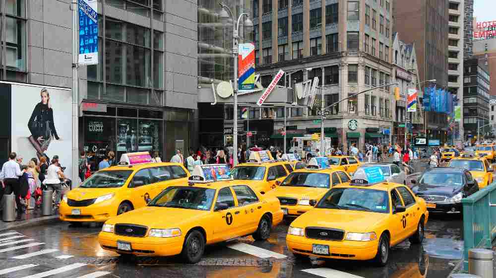 People ride yellow taxi cabs along 8th Avenue | Uber Will Now Include NY Yellow Cab Taxis On Its App | featured