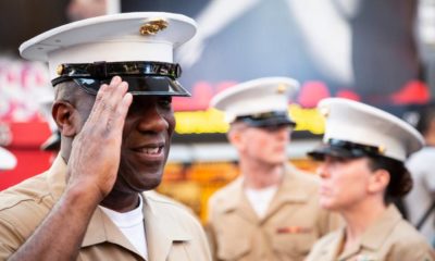 USMC officer salutes after a commemorative group photo on the red steps in Father Duffy Square during Fleet Week | Racism and Hate Should Not Be Part of the Military | featured