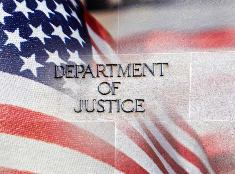 Department of Justice building sign with an American flag behind it | Justice Dept Appeals Court Ruling 