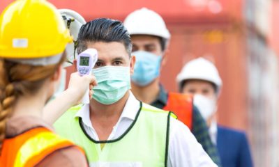 Female worker scanning fever temperature with digital thermometer to construction site | Democrat-led States Handled COVID-19 Worse Than GOP States | featured