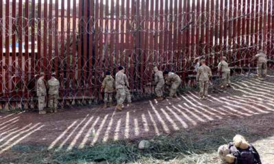 National-guard-troops-attach-razor-wire-to-the-U.S.-Mexico-border-wall-in-Nogales-US-Mexico-Border-ss.jpg