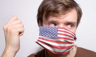 Young American man wearing USA face mask during coronavirus pandemic | Airlines Make Masks Optional After Judge Strikes Down Mandate | featured