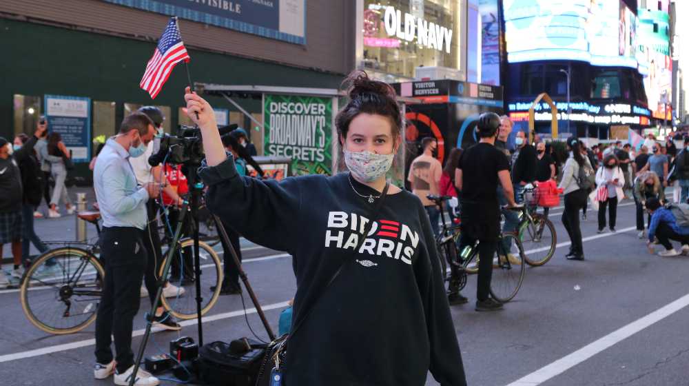 Young woman support President Elect Biden in Times Square | Young Voters Like Biden Less, Popularity Drops From 60% to 39% | featured