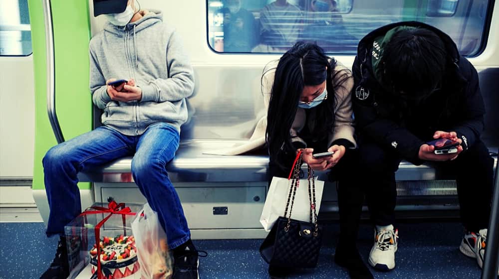 People riding train wearing face mask | Trump Faces Accusers: What to Watch During His Big Speech 