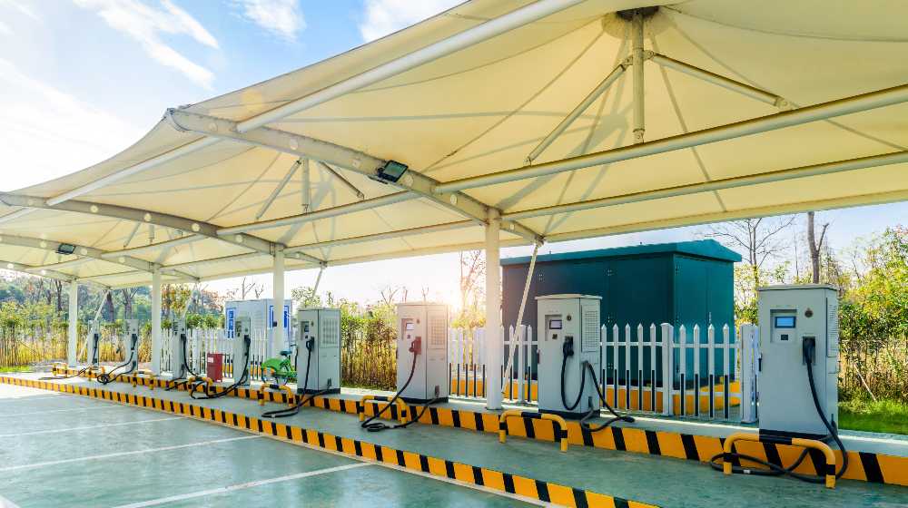 A solar powered electric car charging station in a public parking lot | EV Orders Coming In, But EV Stations Are In Short Supply | featured