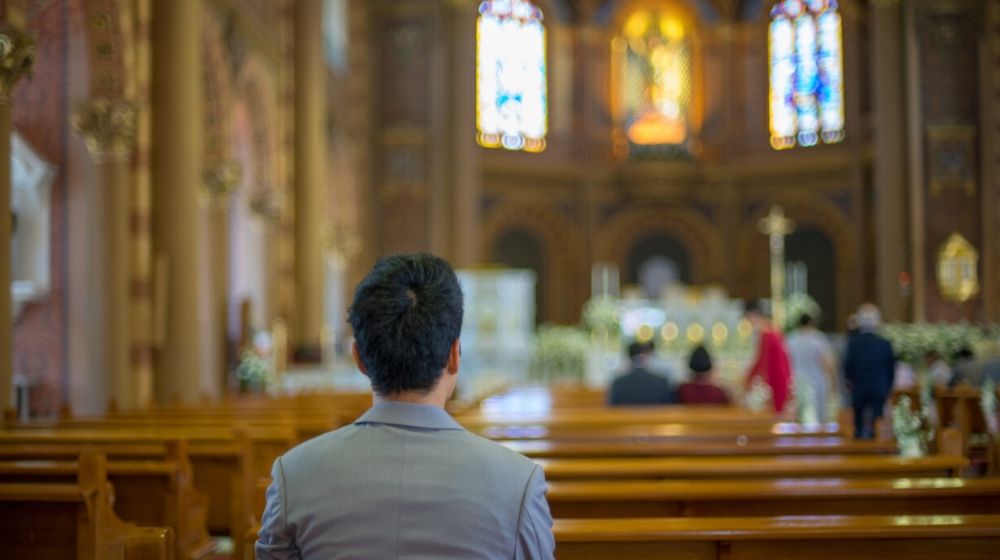 man praying inside the church | Church Pays Off $46.5 Million in Medical Debt for Families | Featured