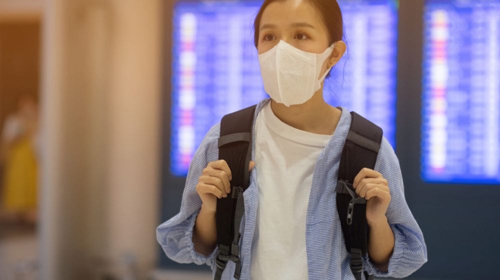 Asian woman on face mask | Quarantine Cruises Half Off: Coronavirus Effect on Travel Industry | Featured