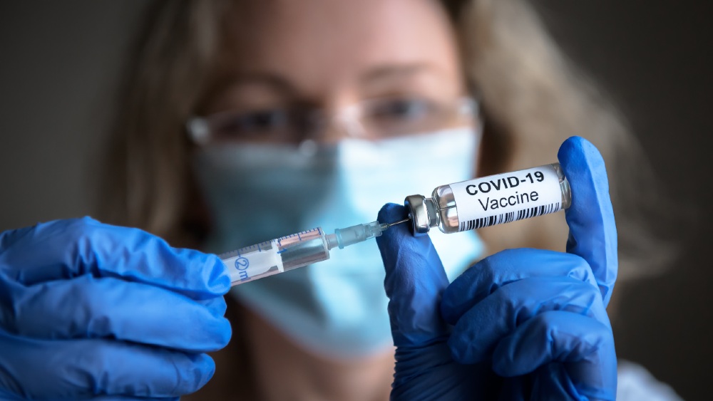 COVID-19 vaccine in researcher hands, female doctor holds syringe and bottle with vaccine for coronavirus cure-Americans Will Refuse-SS-Featured