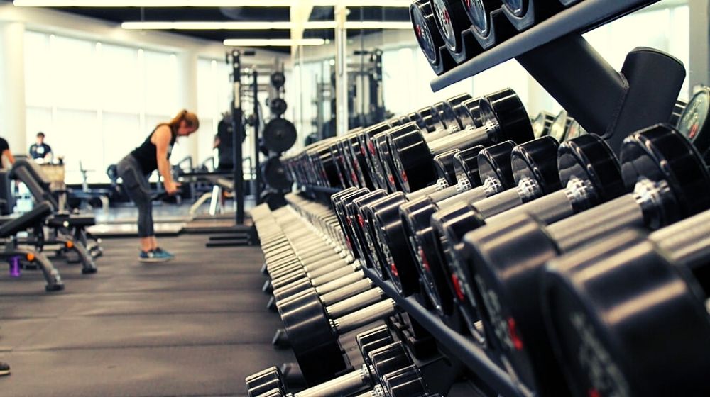 woman exercising alone in the gym | New Jersey Gym Owners Are “Not Backing Down” Against COVID-19 Shutdown | Featured