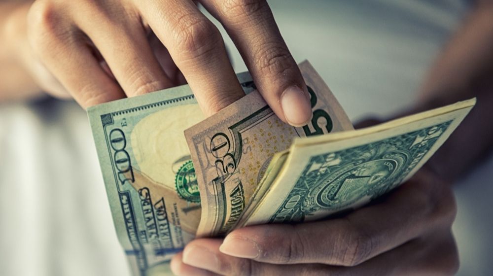 Close-Up Hands Counting Money American Dollars | New Income Calculator Allows Americans to Determine If They Are in the Middle Class | Featured