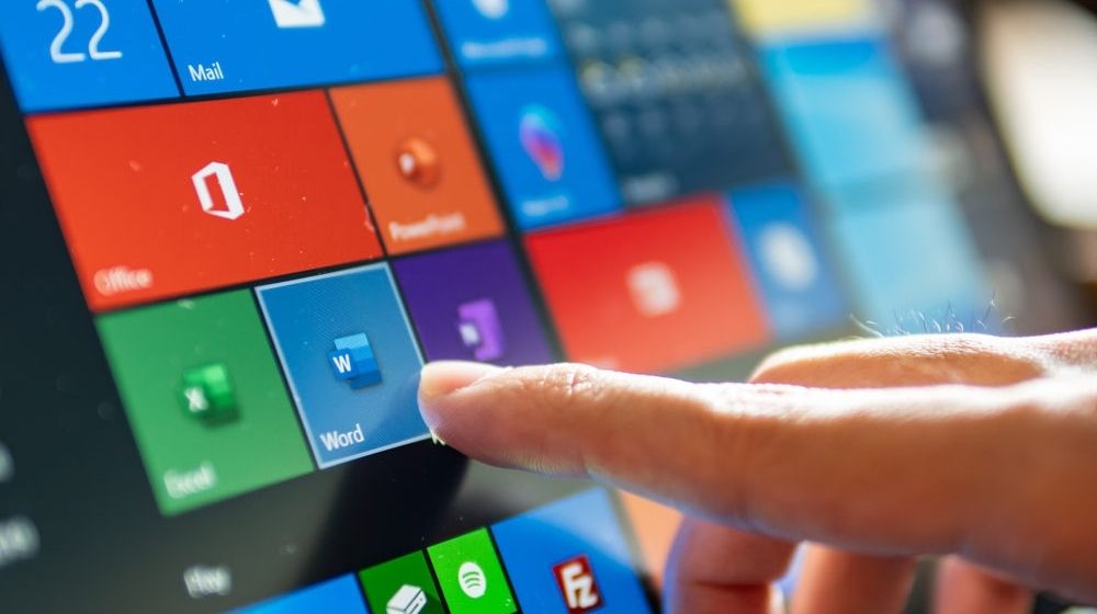 Computer User Touching on Microsoft Word Icon | Windows 10 Updates Seem to Be Breaking Some PCs | Featured