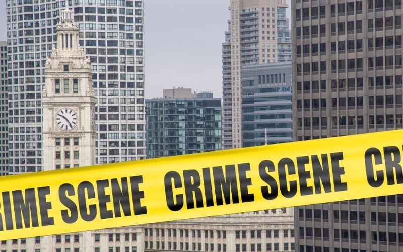Crime Scene Cordon Tape Superimposed over Chicago Skyline | 8 Dead and At Least 19 Wounded in Weekend Chicago Shootings | Featured