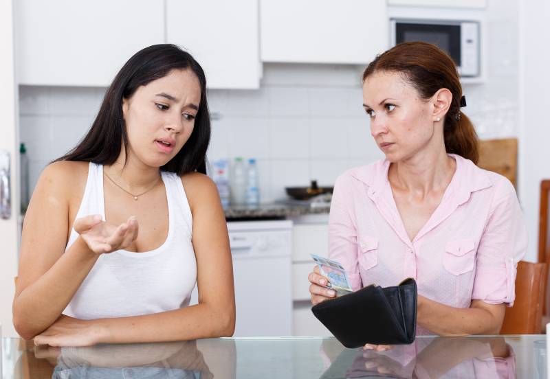 Daughter begging money from her mother in kithen interior | Savings.com Survey: 50% of American Parents Still Financially Support Their Adult Children