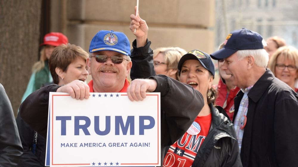 Makes it American Great Again banner with supporter | Trump Supporters Camp Out Ahead of Rally in Colorado Springs | Featured