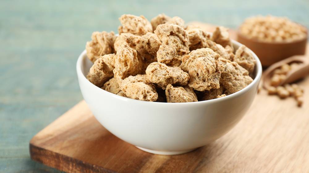 Dried soy meat on light blue wooden table, closeup | KFC To Sell Plant-Based Fried Chicken Starting Next Week | featured