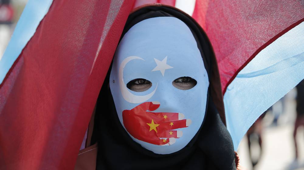 Ethnic Uighurs are seen during a protest against China near the Chinese Consulate | After Telling Suppliers to Avoid Xinjiang Region, Intel Says Sorry | featured