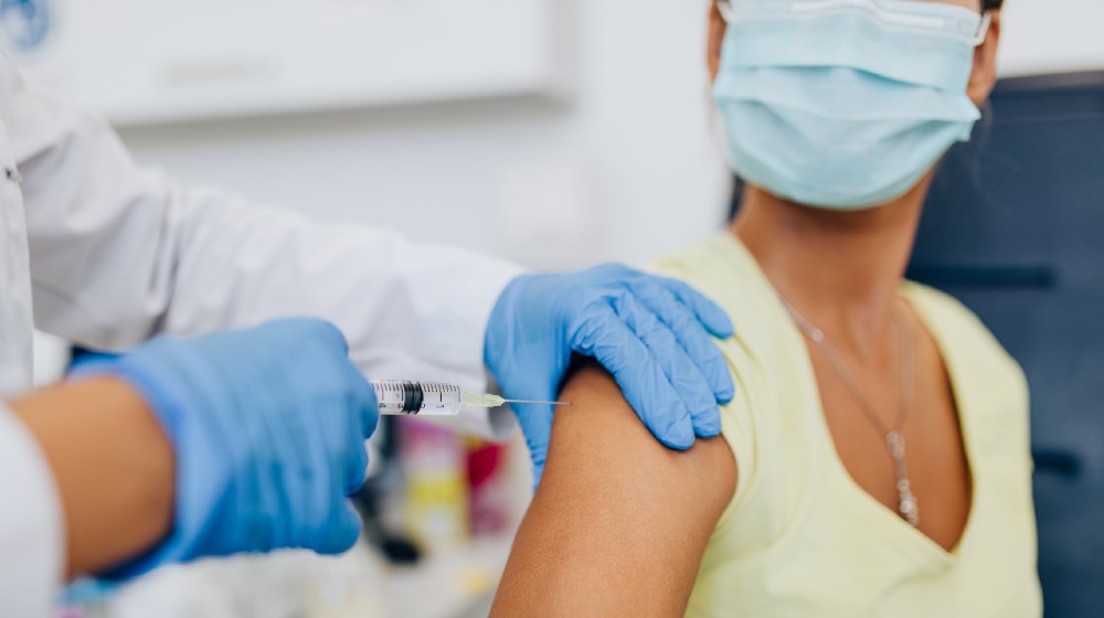 Female doctor or nurse giving shot or vaccine to a patient's shoulder-Enough COVID-19 Vaccines-ss-featured