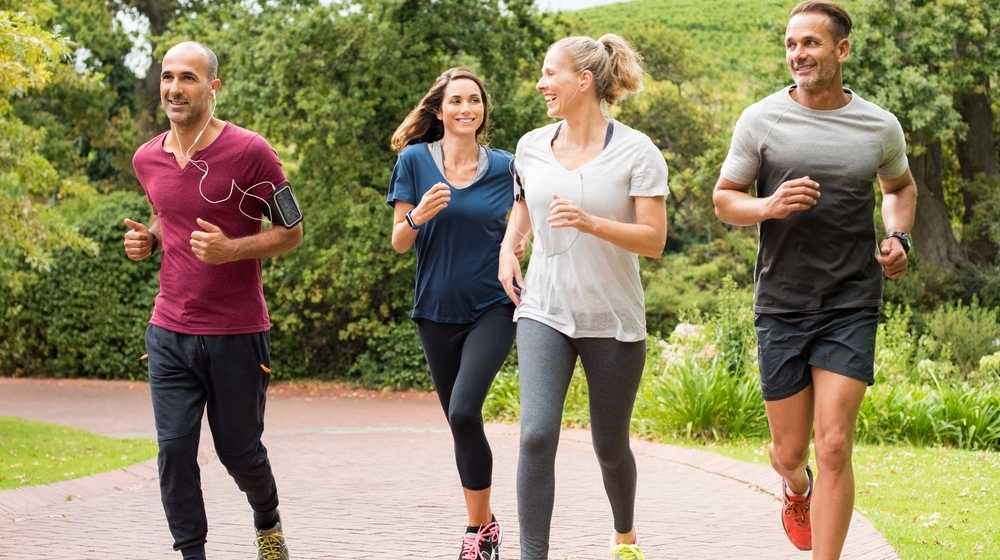 Four people running outdoors-CDC Guidelines Say Fully Vaccinated Americans can Ditch the Mask Except in Crowded Areas-ss-Featured