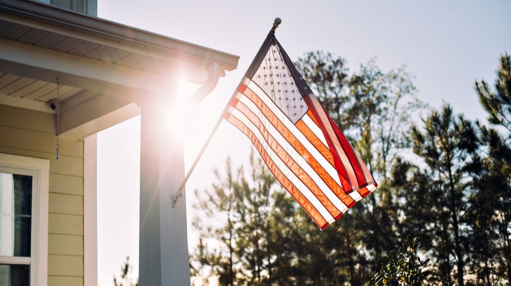 Front side of Typical American Porch Colonial House with American Flag | On Flag Day, Debate over Respect for 'Old Glory' Still Waves | Featured