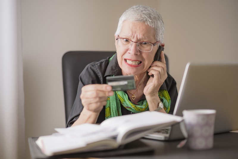 Frustrated senior woman yelling at the bank clerk-Debt Collectors