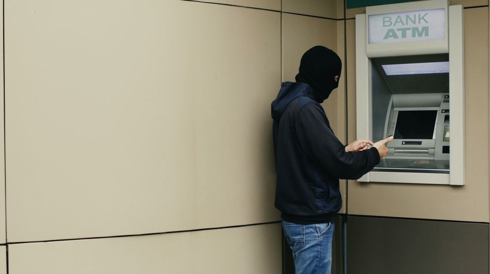 Thief with Black Balaclava in Front of ATM Machine | Man Dies After Attempting to Break into an ATM Using Explosives | Featured