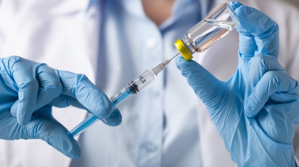 Doctor Holding Vaccine Coronavirus Treatment Here, Vaccine in Sight | Featured