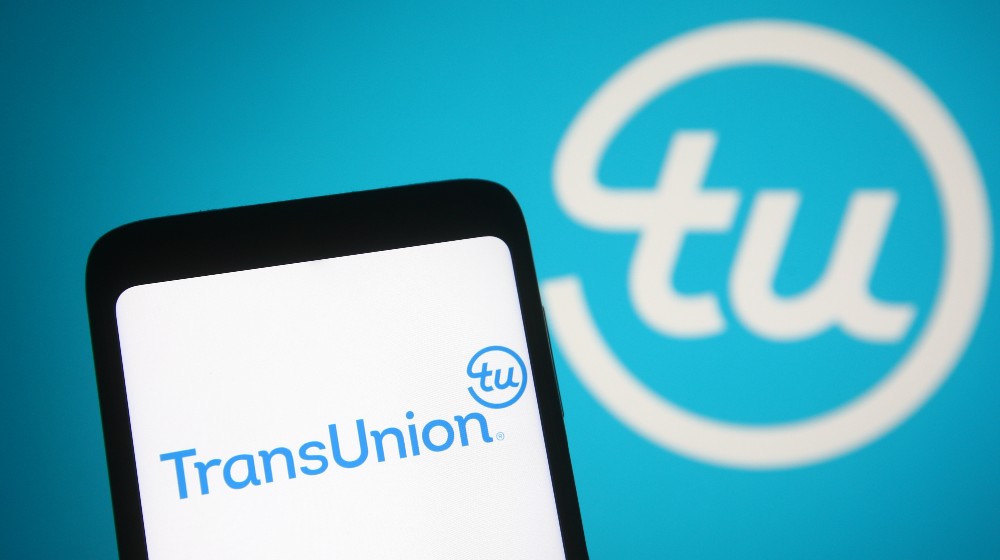 In this photo illustration TransUnion Holding Company, Inc | CFPB Sues TransUnion for Deceptive Marketing Practices | featured
