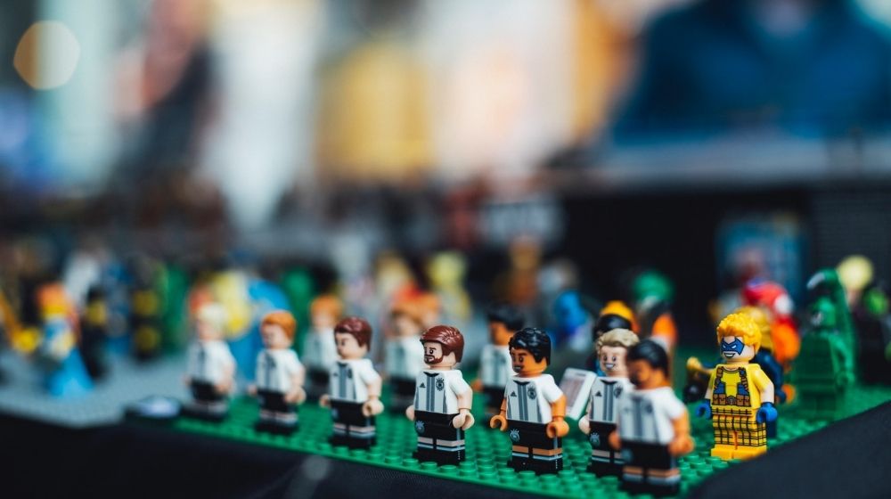Lego Figure on Green Surface Photo | LEGO Launches Line of Braille Brick Tool Kits | Featured