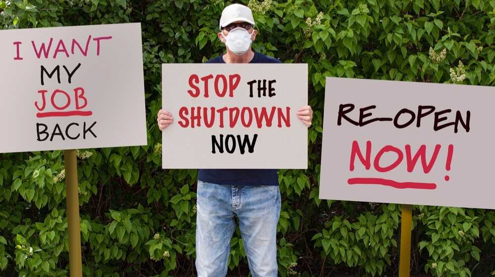 Man protesting against lockdowns-Democratic States Lost Double The Jobs Republican States Lost During Pandemic-ss-Featured