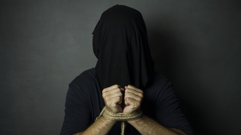 Man with tied hands and black bag on his head | 16 American Missionaries Kidnapped In Haiti | featured