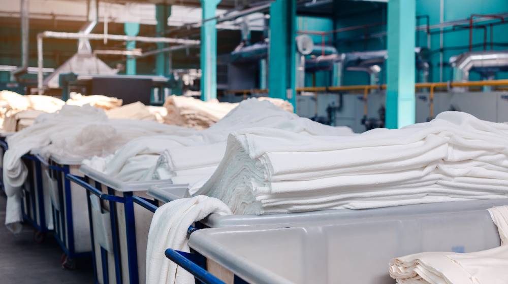 Material on the textile factory. Rolls of industrial cotton fabric for clothing cloth textile manufacture on machine | World's Top 10 Textile Companies | featured