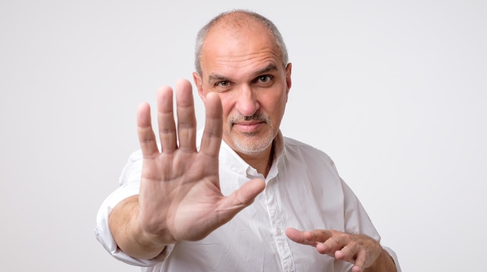 Mature man in white shirt showing sign stop with hand. Deny to do something-Denying-ss-featured
