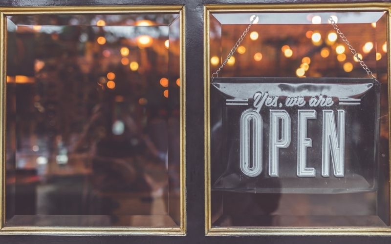 Open Vintage Sign Broad through the Glass of Store Window | What to Watch Out For As the Country Opens Up