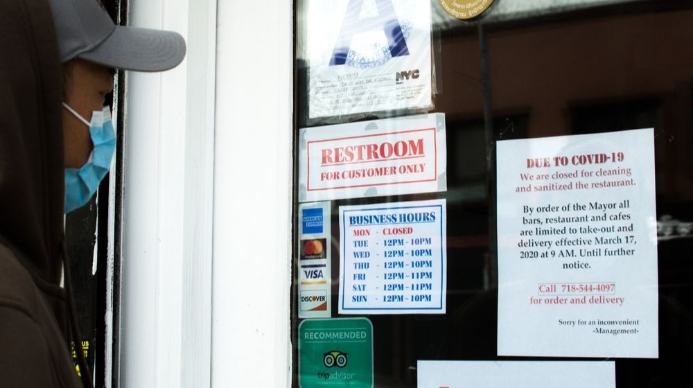 Person Looking at Closed Restaurant Sign Covid19 | Third of NYC’s 230,000 Small Businesses May Never Reopen | Featured