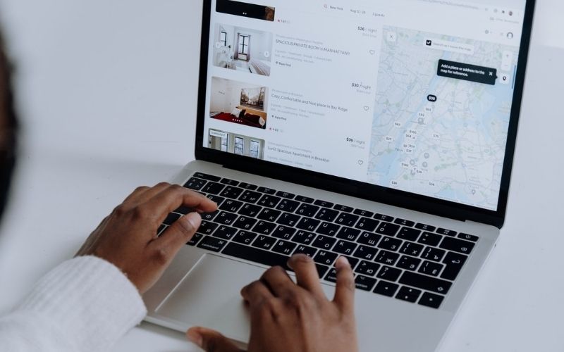 Person Using Macbook Pro on White Table | Airbnb Announces Global Ban on Parties and Events