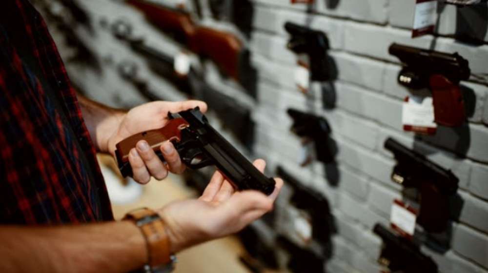Person looking at a handgun-Thank God For Texas House Passes ' Constitutional Carry ' Bill For Residents to Carry a Gun without a License-ss-Featured