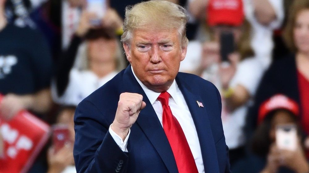 President Donald Trump Gestures the Confident Fist Pump on Stage | America Chooses Between Dark Winter and Trump | Featured