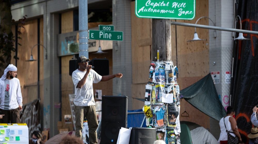Protesters speaking in front of the abandoned Seattle East Precinct Police Station | CNN Calls Seattle Autonomous Zone 'Peaceful' Despite Armed Checkpoints | Featured