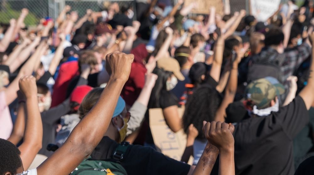 Protestors Raise their Hands in Solidarity Outside of the Fifth Police Precinct in Minneapolis | Minnesota Gov. Tim Walz Asks Trump for Federal Disaster Declaration Following Damages | Featured